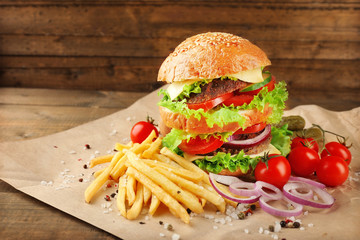 Hamburger with fries on wooden background