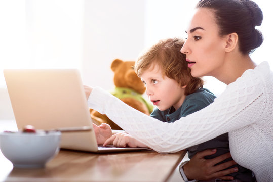 Mother and child looking attentively at laptop