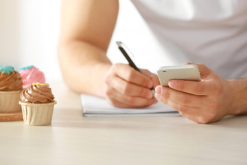 Man counting calories on table