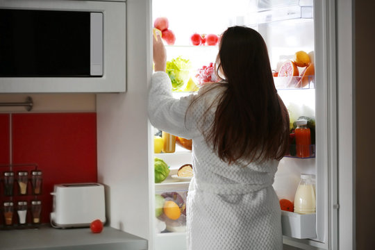 Young Beautiful Woman Looking Into Fridge At Night