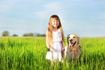 Little girl and big kind dog on the meadow