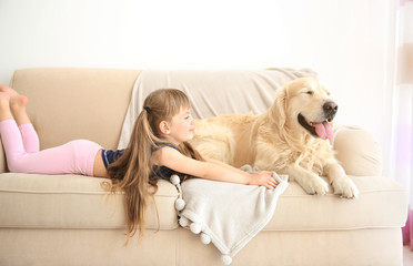 Little girl and big kind dog on sofa