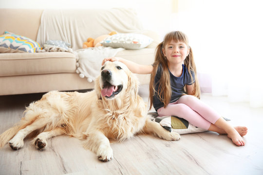 Little girl and big kind dog in the living room