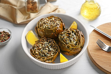 Tasty backed artichoke on a white plate, close up
