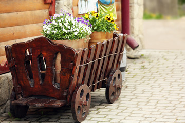Yellow buckets with flowers in wooden cart