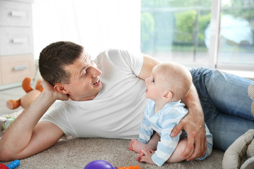 Cute baby with father on the floor