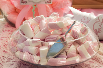Pink and white marshmallows on a table.
