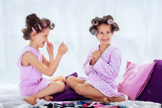 happy children in curlers do hair and makeup