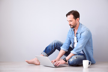 Man using laptop on grey background