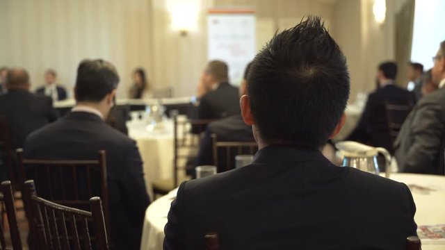 A young man listens at a business event