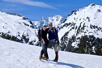 Happy friends hugging on snow covered mountain top. Mount Shuksan, North Cascades National Park,...