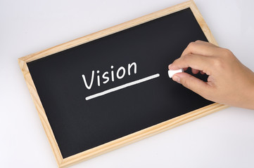 Women Hand Holding Chalk Writing "Vision" Word On Black Board