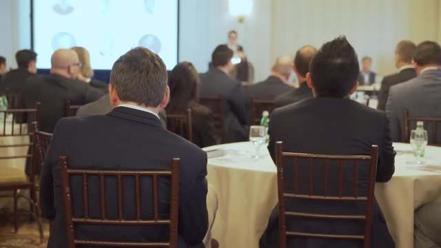 Businessmen listen at a conference
