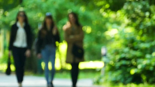 Slow motion. Figures of three girls  in summer day. Blurred scene