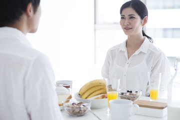 Newlyweds are facing are eating breakfast