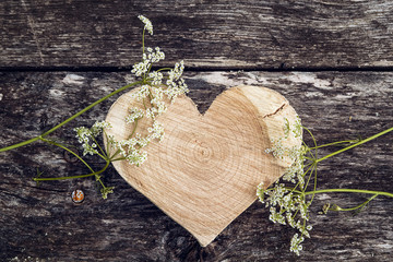 Carved wooden heart and white flower on a background of old boar - Powered by Adobe