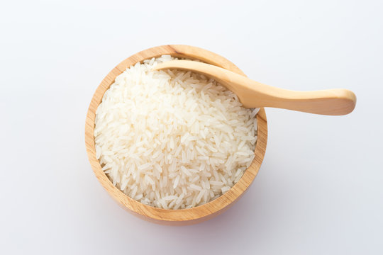 wooden bowl of jasmine rice grain on white background