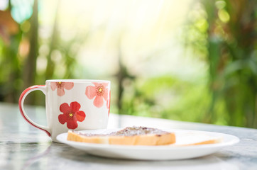 Closeup cute cup on blurred marble desk and garden view in the morning textured background