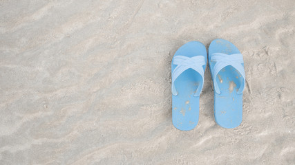 Fototapeta na wymiar Blue sandals at the beach with copy space