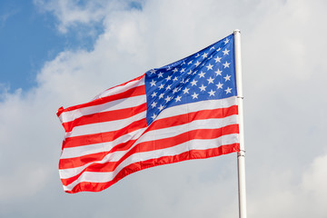 Close-up American flag with flag pole on clear blue sky backgrou