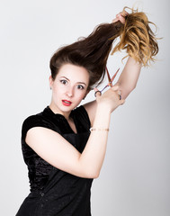 Fototapeta premium female Hairdresser trying to cut your own hair with scissors