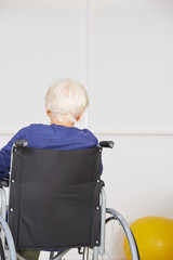 Seniorin sitzt einsam im Rollstuhl im Altenheim