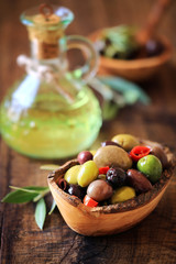 Olives a la Provencale. Provencal style mixed pitted olives on dark rustic wooden background