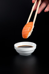 Salmon sushi on black background from side