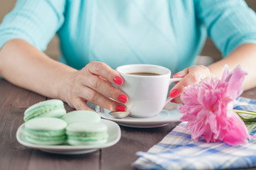 Female hands holding colorful french macaroons
