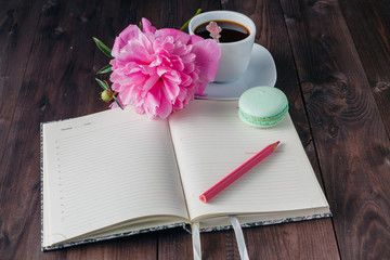 Cup of coffee with notebook on the wooden background