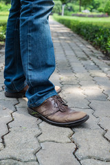 Man wearing jeans walking on the path to the park or garden