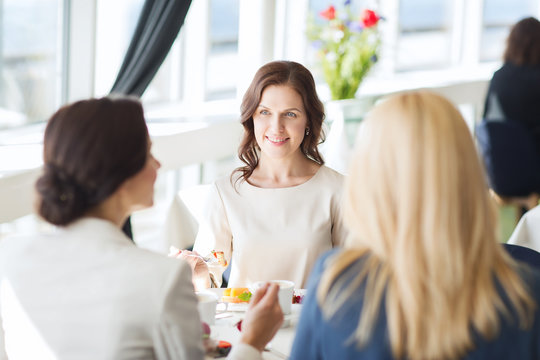 women eating dessert and talking at restaurant