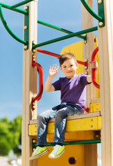 happy little boy climbing on children playground