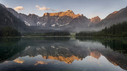 Panorama jeziora górskiego,góry oświetlone wschodzącym słońcem - obrazy, fototapety, plakaty