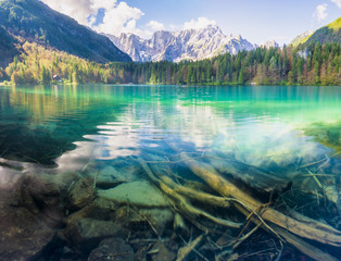 Panorama jeziora górskiego,góry oświetlone wschodzącym słońcem - obrazy, fototapety, plakaty
