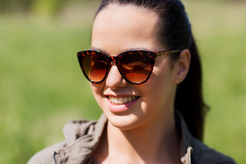 face of happy young woman in sunglasses outdoors