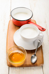 Fototapeta na wymiar warm milk and a bowl with honey