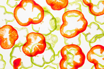 Sliced green and red pepper rings  on a white background. Decorative pattern. Food background. Concept art.