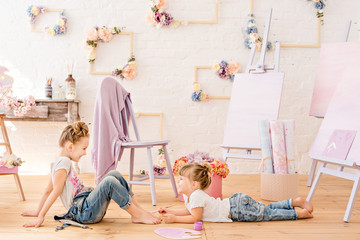 Sisters play and indulge, do manicure with brushes and paints to paint