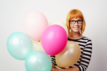 attraktive frau mit brille hält luftballons in den händen