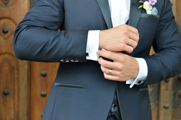 Hands of wedding groom in a elengant suit getting ready. Details