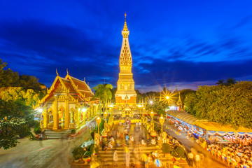 Thai people walking with lighted candles in hand around a temple candles light trail of pagoda at Phra That Phanom Temple on Visakha Bucha Day, Nakhon Phanom Province, Thailand