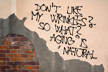 Do Not Like My Wrinkles? So What? Aging Is Natural - handwritten graffiti sprayed on the wall,...