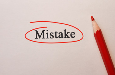 Mistake in red circle with pencil on textured paper