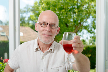 middle-aged man drinking a glass of wine