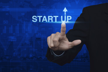 Businessman pressing start up icon over map and city background,