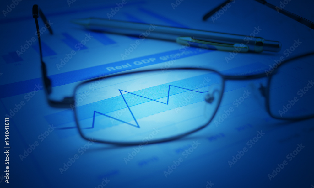 Wall mural glasses and pen on blue financial chart and graph, blue tone, su