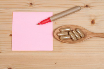 Herbal capsules on wooden spoon. herb for healthy