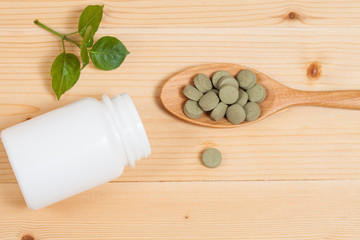 Fototapeta na wymiar Herbal pill on wooden spoon. herb for healthy living.