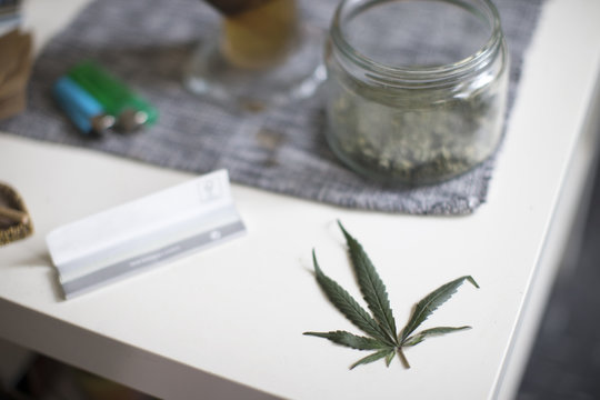 Drug Paraphenalia On Table With Cannabis Leaf